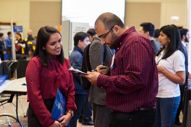 Two people speaking at a career fair